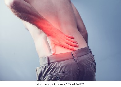 Lumbago Symptom. Young Man Holding His Painful Inflamed Loin. Health Care And Medicine.