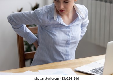 Lumbar Backpain In Office Concept, Tired Fatigued Business Woman Worker Rubbing Back Feel Pain Injury Suffer From Lower Backache After Sedentary Computer Work Sit In Incorrect Posture, Close Up View