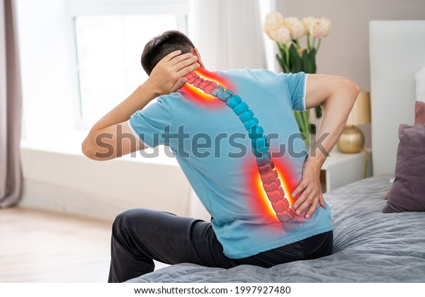 Lumbar and cervical spine hernia, man with back\
pain at home, compression injury of the intervertebral disc, photo\
with highlighted\
skeleton