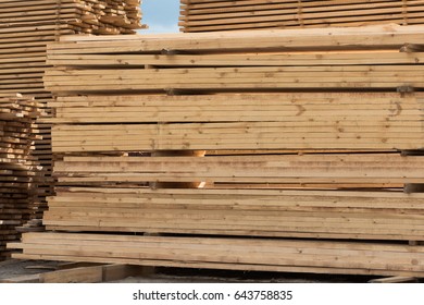 lumber, boards and beams lie in a pile at the sawmill - Shutterstock ID 643758835
