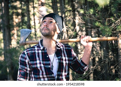 Lumberjack man with his ax on his shoulder in the forest