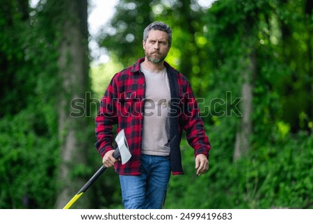 Lumberjack with plaid shirt on nature background. Brutal lumberjack. Cutting wood. Sharp blade. Brutality and masculinity. Bearded lumberjack. Lumberjack style. Man with axe. Bearded man hold axe.