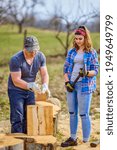 Lumberjack teaching his apprentice how to split logs with the heavy axe