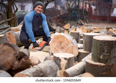 Lumberjack working on beech logs with chainsaw
