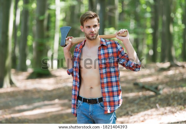 Lumbersexual\
trend. Bearded man carry axe natural landscape. Sexy guy wear open\
plaid shirt with masculine look. Masculine appeal. Barbershop. Hair\
salon. Tree chopping. Summer\
vacation.