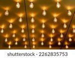 Luminous light bulbs in a row on the ceiling. Theatre light bulbs background.