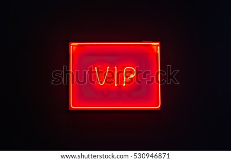 Luminous red neon sign of VIP on a dark background
