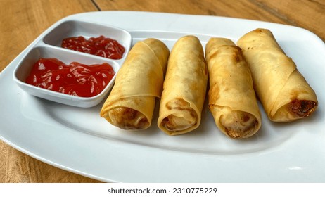 Lumpia or Loenpia Goreng, Deep Fried Spring Roll Served with tomato Sauce and chili sauce. Lumpia is a traditional Chinese snack and is a culinary specialty from Semarang, Indonesia - Shutterstock ID 2310775229