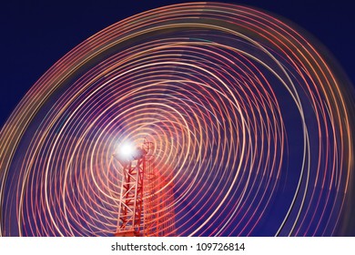 luna park ferries wheel motion blur illuminated at sunset blue sky