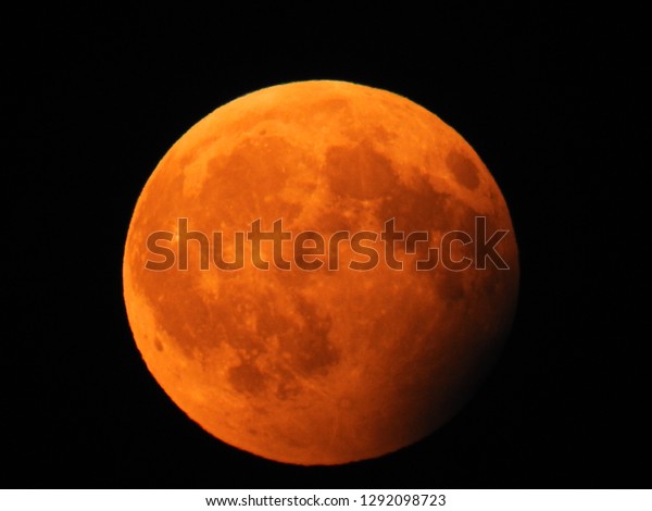 Lunar Eclipse with blood\
moon. Big moon in its full phase with detailed craters visible on\
its edges.