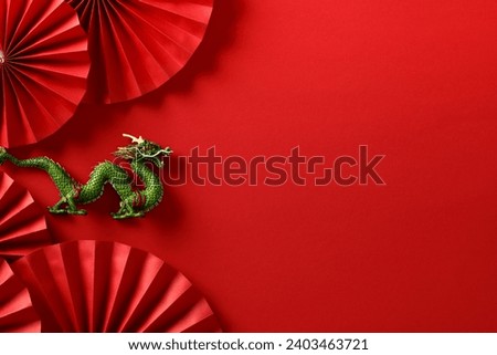 Lunar new year 2024 concept. Chinese dragon with folding paper fans on red background.