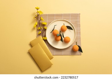 Lunar New Year with mandarin orange, bamboo blind, yellow apricot flower, and lucky envelopes on yellow background.  AsiaTraditional Holiday.