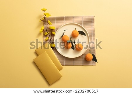 Lunar New Year with mandarin orange, bamboo blind, yellow apricot flower, and lucky envelopes on yellow background.  AsiaTraditional Holiday.