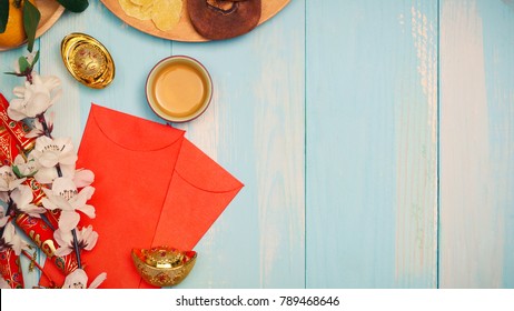 Lunar new year.Firecrackers and Chinese gold ingots and Traditional Red envelopes and decoration with Fresh oranges on wooden background
