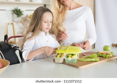 Lunch Box With Appetizing Food And School Bag On Kitchen Background. Homemade School Sandwiches.Packing In School Lunchbox.Mom Preparing School Snack Or Lunch For Her Daughter In Home Kitchen.