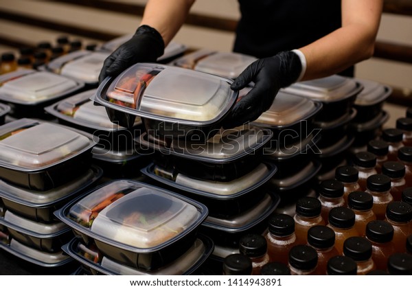 Lunch box with food\
in the hands. Catering
