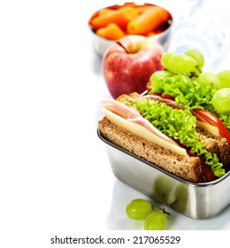 Lunch Box With Sandwich, Fruits And Water On White Background