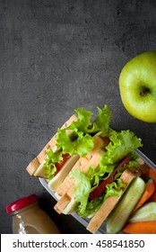 Lunch Box With Sandwich, Vegetables, Juice, Nuts And Apple On Black Background. Healthy Eating. Flat Lay.