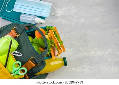 Lunch Box, School And Office Supplies, Medical Face Mask On A Light Background. Back To School Concept. Social Distance, Learning And Home Education. Stay Safe. Top View Copy Space.