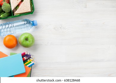 Lunch Box With Vegetables And Sandwich On Wooden Table. Kids Take Away Food Box And School Supplies. Top View With Copy Space