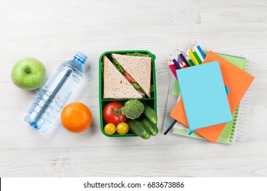 Lunch Box With Vegetables And Sandwich On Wooden Table. Kids Take Away Food Box. Top View