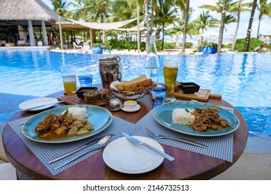 Lunch By A Swimming Pool During A Vacation In Mauritius, A Tropical Setting With Lunch Drinks And Curry By A Pool. 