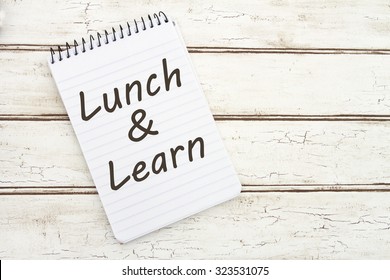 Lunch And Learn, A Spiral Notepad That Has The Words Lunch And Learn Over A Distressed Wood Background