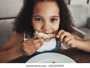 Lunch, portrait and child eating chicken in the dining room at a party, dinner or event at home. Hungry, happy and girl kid enjoying food or meal at the table for snack, hunger or craving at a house. - Powered by Shutterstock