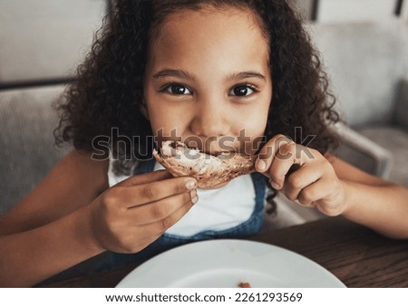 Lunch, portrait and child eating chicken in the dining room at a party, dinner or event at home. Hungry, happy and girl kid enjoying food or meal at the table for snack, hunger or craving at a house.