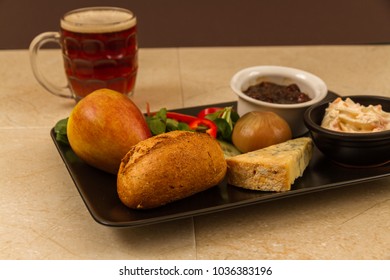 Ploughmanâs Lunch With Stilton Cheese, Pickle, Pickled Onion, Salad, Coleslaw And Bread Roll, Apple And Half Pint Of English Ale Or Beer.