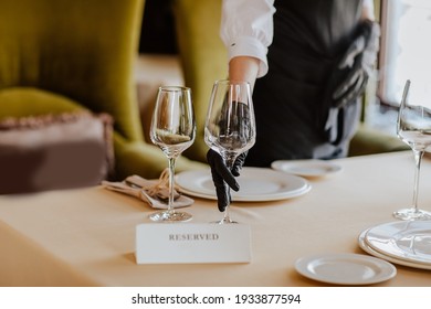 Lunch tablecloth with white plates, glasses and received name plate in restaurant. Focus is at glasses - Powered by Shutterstock