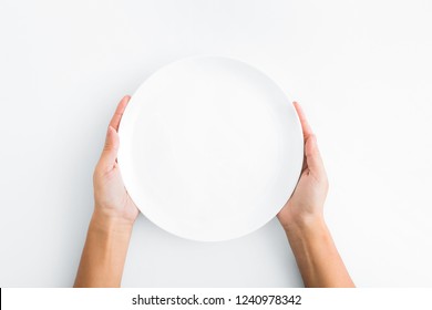 Lunch Time. Female Hands Holding Empty Plate On White Background, Top View, Copy Space