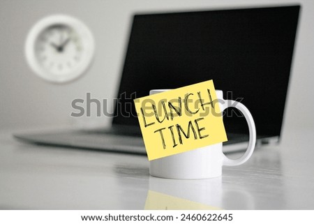 Lunch time in the office is shown using the text on the cup and photo of clock. Time for a break