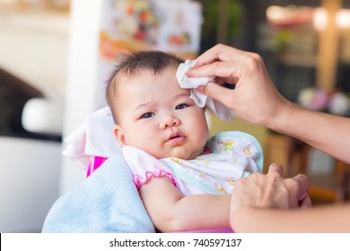 Lunch Time Over Blurry Background. Baby Is Hungry So Parent Feed Her By Spoon. She Is So Happy When She Eats His Favorite Food Such As Egg, Soup, Meat And Etc .after She Is Full,mother Wipe Her Face.