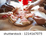 Lunch time at pizzeria, multiracial people grabbing huts of delicious pepperoni pizza, close up. Food and Party concept