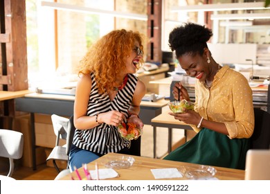 Lunch time. Two best friends working together laughing while having lunch time in the office - Powered by Shutterstock