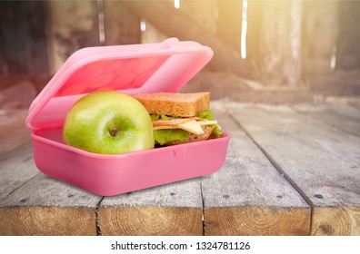 Lunchbox With An Apple And Sandwich On Table