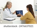 Lung cancer. Doctor showing chest x-ray on laptop to her patient in clinic