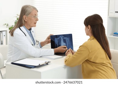 Lung cancer. Doctor showing chest x-ray on laptop to her patient in clinic