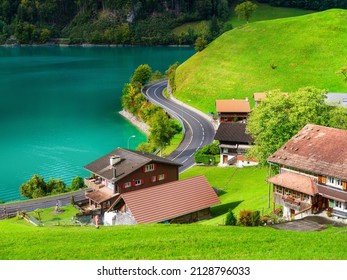 Lungern, canton of Obwalden, Switzerland. A view of rural homes in a green meadow. A lake in a mountain valley. A popular place to travel.