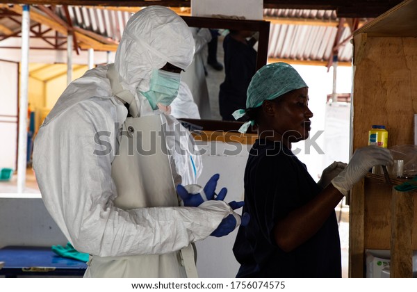 Lunsar, Sierra Leone - April 29,2015: a nurse and\
a medical worker prepared with safety equipment to enter dangerous\
zone of an ebola treatment center to check patients evolution.\
Pandemic context