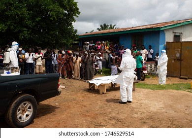 Lunsar, Sierra Leone - July 8, 2015: Burial Team And Family Praying Before Taking The Body Away. Ebola Response Epidemic Disease In Africa, Ebola And Corona Virus Context