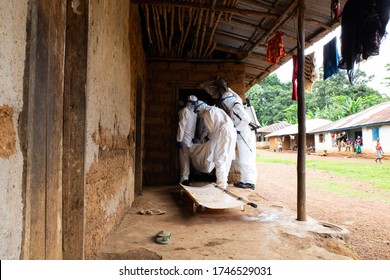 Lunsar, Sierra Leone - June 24 2015: the burial team takes a dead person from the interior of a house. ebola response epidemic disease in Africa, ebola and corona virus context