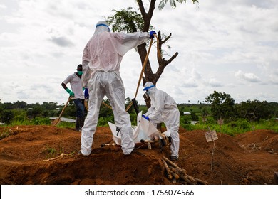 Lunsar, Sierra Leone - June 24, 2015: Members Of The Burial Team Bury An Ebola Dead Person In The Main Cemetery During Pandemic. Ebola Context