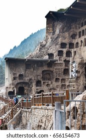 LUOYANG, CHINA - MARCH 20, 2017: people near caves in Chinese Buddhist monument Longmen Grottoes (Longmen Caves). The complex was inscribed upon the UNESCO World Heritage List in 2000