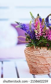 Lupine Flower Bouqet In Wicker Vase On The Wooden Pallet Furniture At Summer Patio