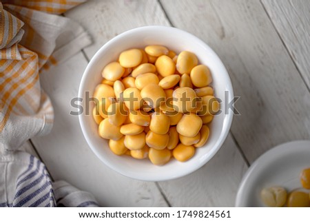 Lupins in a Bowl on a White Wooden Table with Napkins
