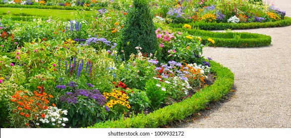 Lush Flower Beds In The Summer Garden. A Bright Sunny Day.Wide Photo.