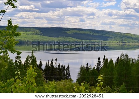 Lush forested landscape casting reflections on Gander Lake during Spring