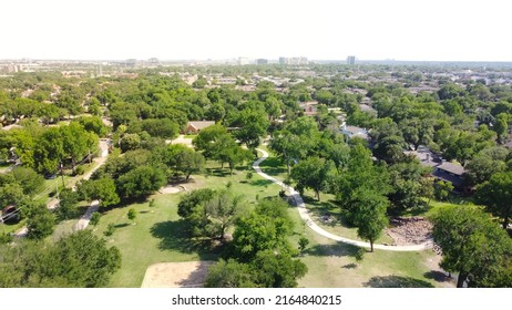 Lush Green Grassy Park With Trail System And Matured Trees Near Established Residential Neighborhood With Downtown Richardson In Background. Aerial View Subdivision Sprawl In North Texas, USA